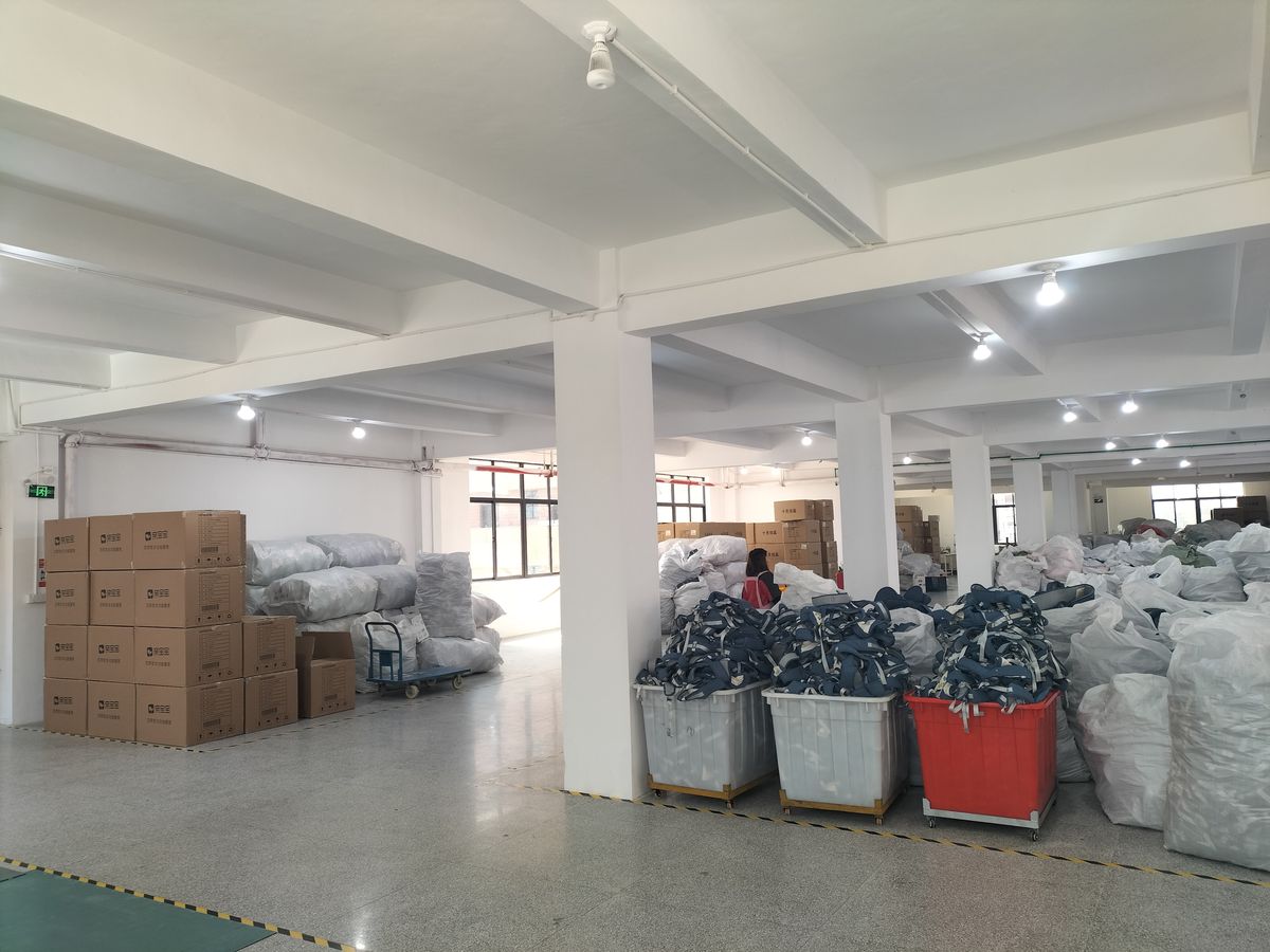 Materials and boxed goods staged against a wall on the production floor.